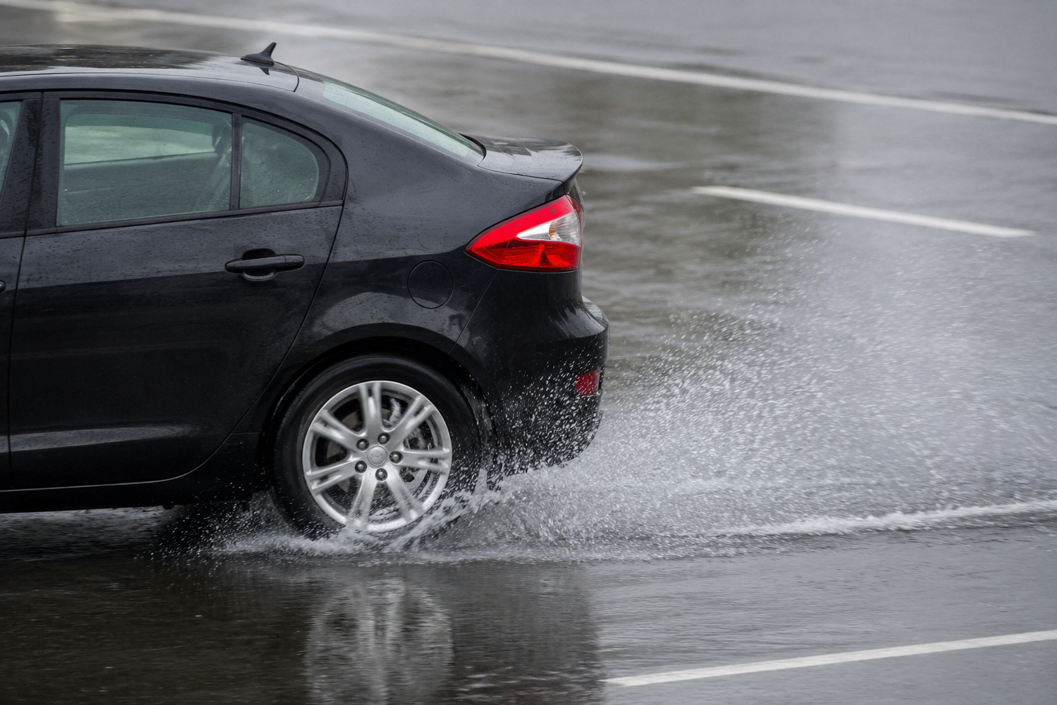 car on wet road car stopping in the rain